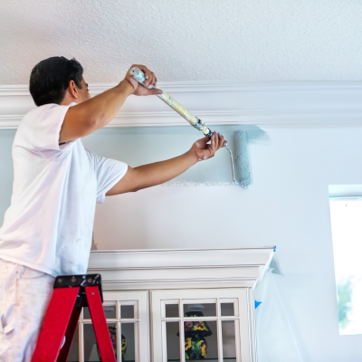 A Pro Painters painting along crown molding. House Painting Service Living room